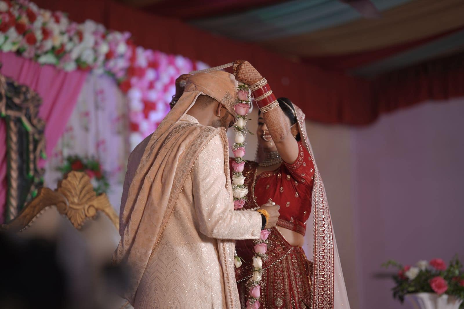 An Indian bride and groom exchanging flower garlands